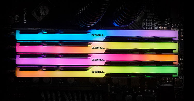  Top view of four Trident Z modules on a motherboard, with each module glowing different colors on the RGB strip  